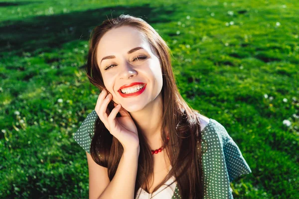 笑顔の女性タッチ、明確な肌、健康笑顔、草の背景 — ストック写真