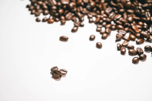 На білому тлі лежать зерен ароматні бразильська кава, арабіка — стокове фото