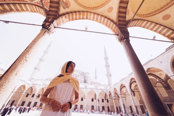 Mujer joven viajera en pañuelo de cabeza de pie sobre fondo azul de la mezquita. Viajar durante las vacaciones de verano — Foto de Stock