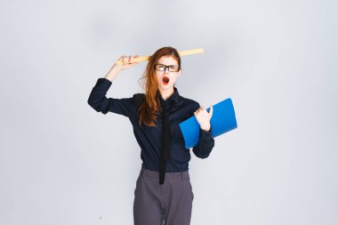 sürpriz Kızıl saçlı kız gözlük ve şık koyu giysiler ile bir klasör belgeler ve bir cetvel ile düzenliyor