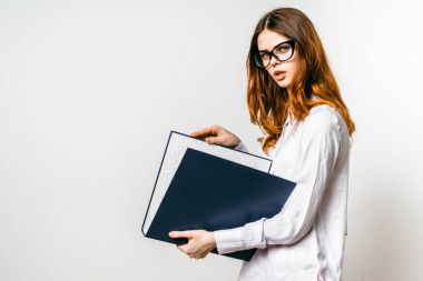 ciddi genç kız gözlüklü bir klasör belgeler ile tutar, kameraya benziyor