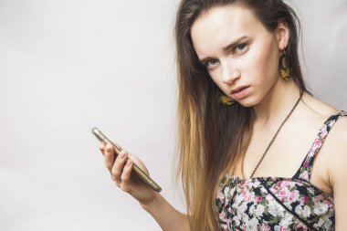 Şüpheci yüz kız ile smartphone, kameraya görünüyor