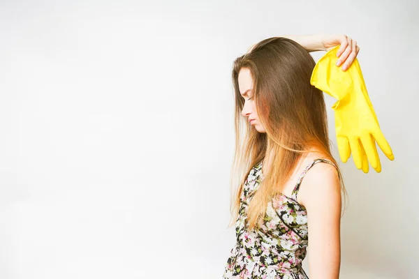 A young long-haired girl does not want to get out, is holding yellow rubber gloves — Stock Photo, Image