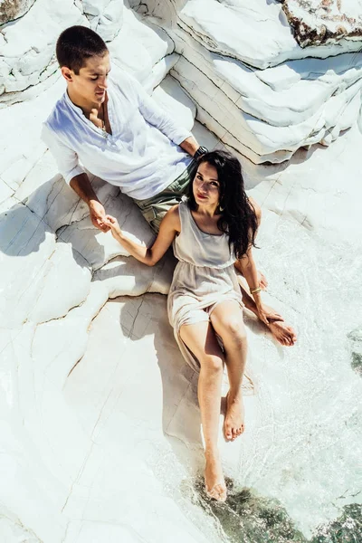 Una giovane coppia di amanti si trova in una bella acqua limpida vicino a rocce bianche in vacanza — Foto Stock