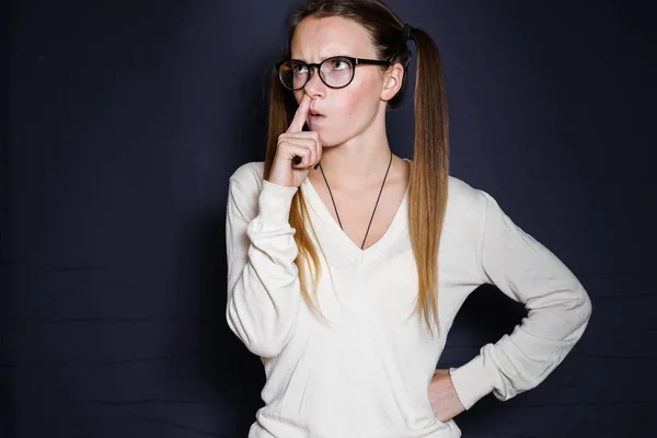 Uma jovem com óculos e uma jaqueta branca pensou em algo — Fotografia de Stock