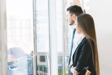 başarılı tek fikirli adam ve kız ofiste pencereden dışarı bakarak