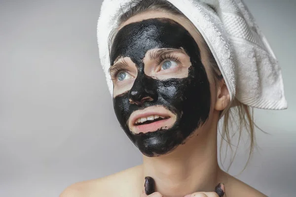 Masque noir sur le visage de la femme, sourire, soins de la peau, nettoyage des pores, contre l'acné — Photo