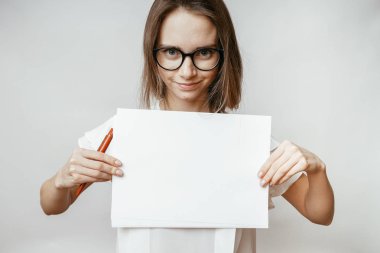 gülümseyen ve kameraya bakarak gözlük, çözmemize genç öğretmen ile boş a4,