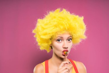 genç kız sarı palyaço peruk içinde yemek chupa chups