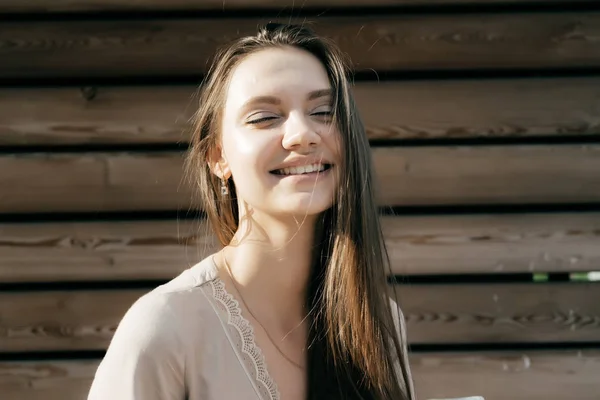 Menina atraente feliz em um vestido bege ri nos raios do sol — Fotografia de Stock