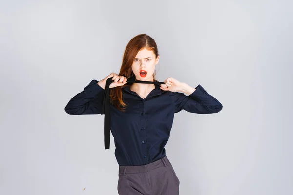 Menina zangada elegante em uma camisa azul desamarra um laço — Fotografia de Stock