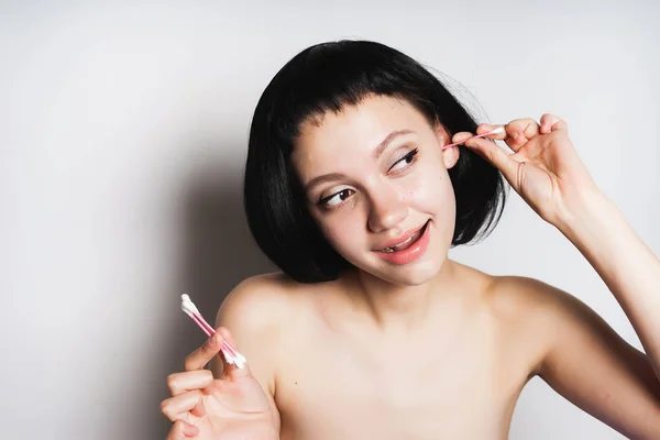 Vicces fiatal lány, Fekete hajú, tisztítja a fülek vattatampon — Stock Fotó