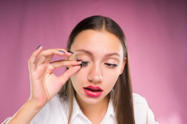 Genç bir kız bir kirpik bindirme bırakır