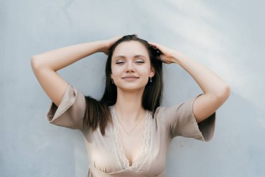 Siyah saçları gri yaz elbiseli bir kız ayarlar