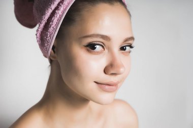 Kız dört gözle gülümseyen başında bir havlu ile