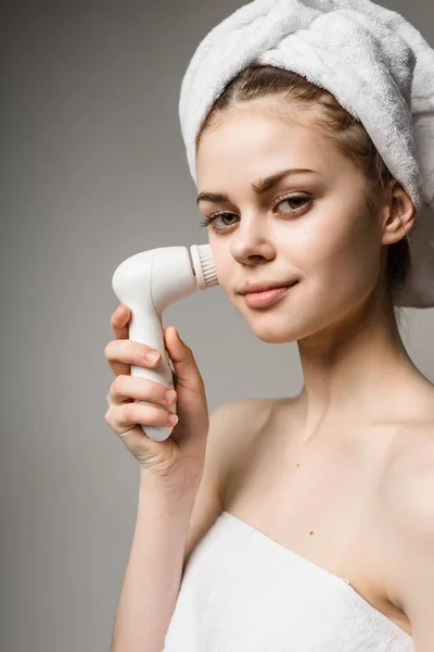 Una ragazza con un asciugamano sulla testa sorridente pulisce la sua pelle — Foto Stock