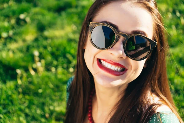 Счастливая улыбающаяся женщина в очках, девушка в деревянных солнечных очках — стоковое фото
