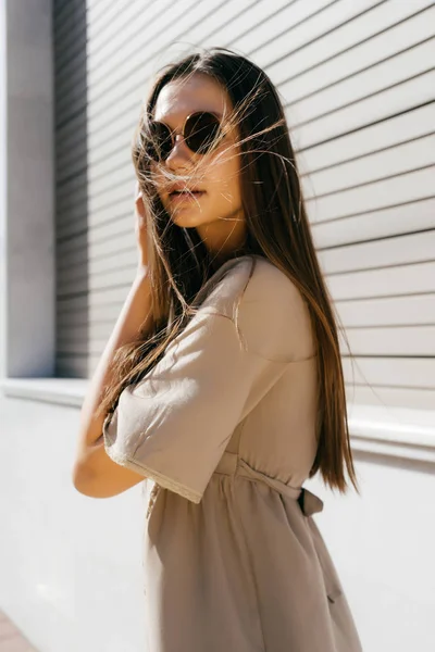 Uma menina em roupas de verão e óculos de sol andando ao longo da rua — Fotografia de Stock