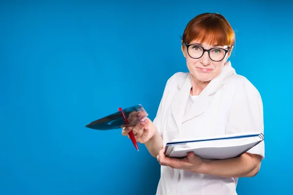 Женщина-врач с удивленным жестом на синем фоне — стоковое фото