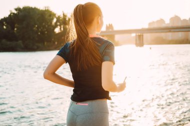 gün batımında nehrin koşan sportif uzun saçlı kız