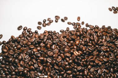 Beyaz bir tablo üzerinde kahverengi güzel kokulu Brezilyalı arabica kahve taneleri yalan