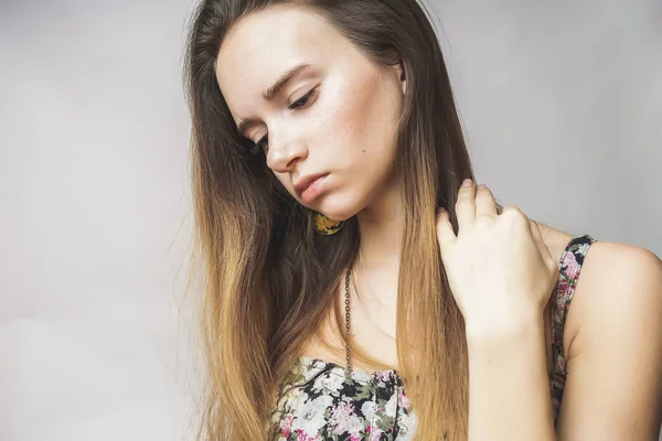 Mujer de verano molesto con el pelo largo piensa en algo, mira hacia abajo —  Fotos de Stock