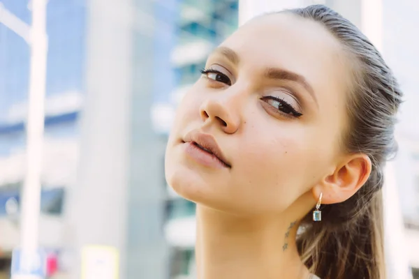 Giovane ragazza attraente guardando la fotocamera, passeggiando per la città — Foto Stock