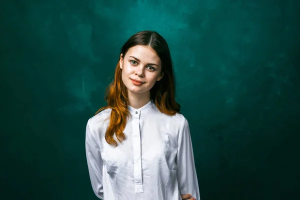 Linda chica en una blusa blanca sonriendo mirando a la cámara, sobre un fondo verde, aislado — Foto de Stock