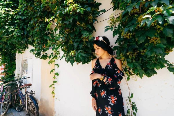 Mujer de pie en las plantas en la pared, flores corona en la cabeza, mujer turca — Foto de Stock