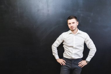 Beyaz bir gömlek siyah bir arka plan üzerinde poz emin başarılı genç adam