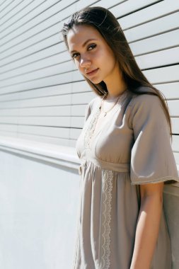 poz, kameraya bakarak bej elbiseli çekici uzun saçlı kız