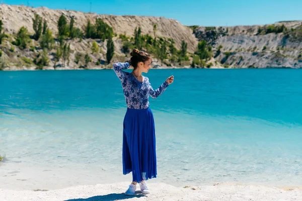 Donna rilassarsi all'esterno, in un abito blu si gode l'acqua blu chiaro — Foto Stock