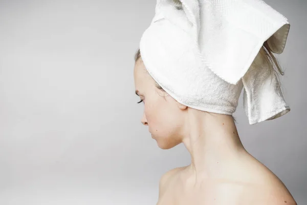 Vacker kvinna med handduk på huvudet ser att kameran, smile — Stockfoto
