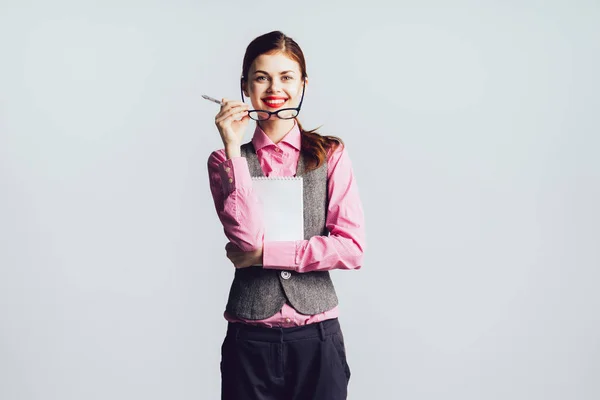 Smějící se stylová holka v růžové košili v rukou drží brýle a dokumenty — Stock fotografie