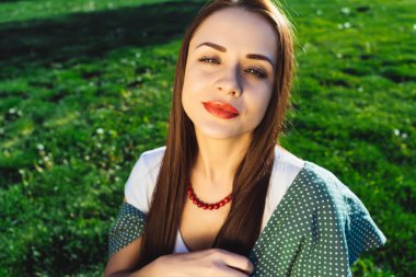 Seksi başarılı genç kadın, çim arka plan, boşaltmak, kameraya görünüyor