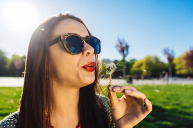 Mutlu gülümseyen komik surat kız darbe karahindiba, yaz güneş gözlüğü, günbatımı