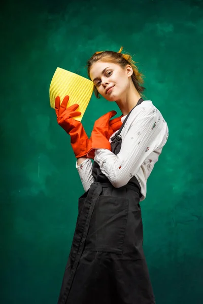 The girl is going to clean. a woman in orange gloves holds a yellow rag in her hands — Stock Photo, Image