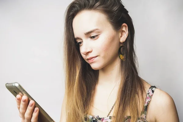 Mooie jonge vrouw met mobiele telefoon het texting, zoek iets — Stockfoto