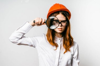 Bir kız bir portakal inşaat kask içinde Büyüteç görünüyor