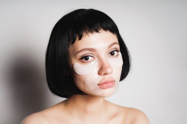 Yüzünde bir krem ile siyah saçlı bir hayal kırıklığına kız