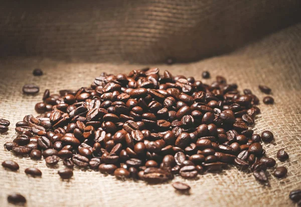 Багато смажених кавових зерен лежать у сумці — стокове фото