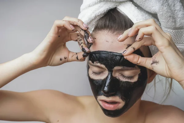 Mulher remover carapaça preta.Cara de caranguejo, poros de esfoliação, pele limpa — Fotografia de Stock