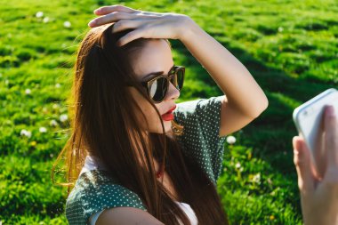 Kadının selfie dışında boşaltmak yapması. sıcak güneşli yaz gün, yeşil çim