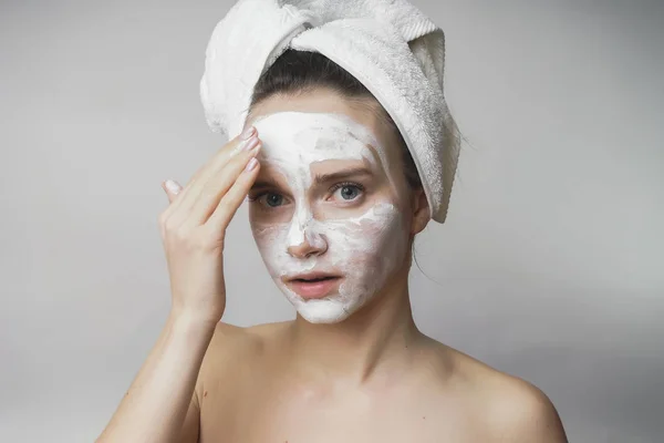 Femme obtient masque blanc sur le visage, appliquer gommage — Photo