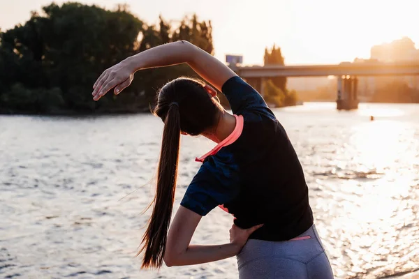 Kız nehir kıyısında egzersizleri yapıyor. Kızın yamaçları yaptığı