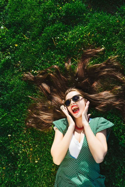 Happy surprised funny face woman view above lying on grass,enjoy,vintage