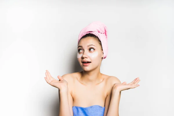 彼女の頭の上のピンクのタオルとカメラを見て彼女の顔にパッチのシャワーの後の幸せな女の子 — ストック写真