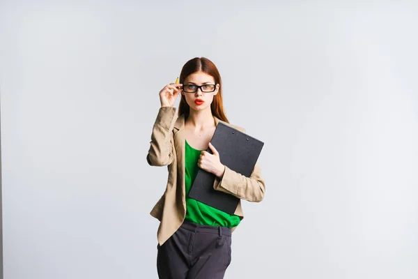 Selbstbewusste, stylische Geschäftsfrau mit Brille, in grünem Sakko, Dokumente in der Hand und posierend — Stockfoto
