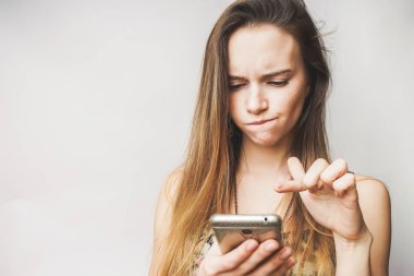 Cep telefonu, beyaz bir arka plan ile kız yüz düşünerek üzgün