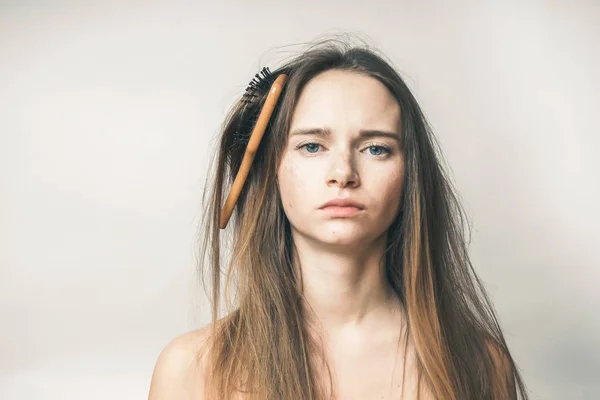Lustiges Gesicht Frau mit Haarkamm, ein Holzkamm in dicken Haaren verheddert — Stockfoto